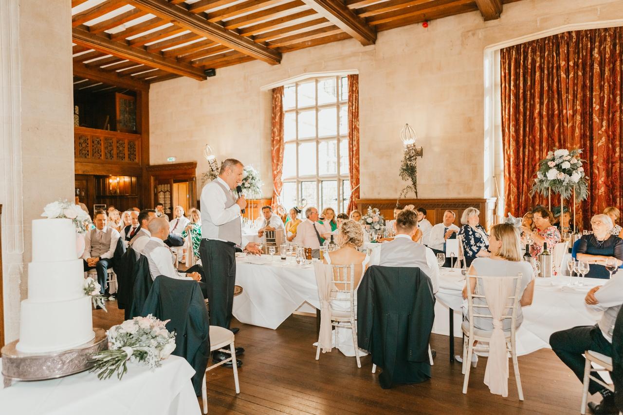 The guests listen at the wedding reception as the father of the bride makes a speech