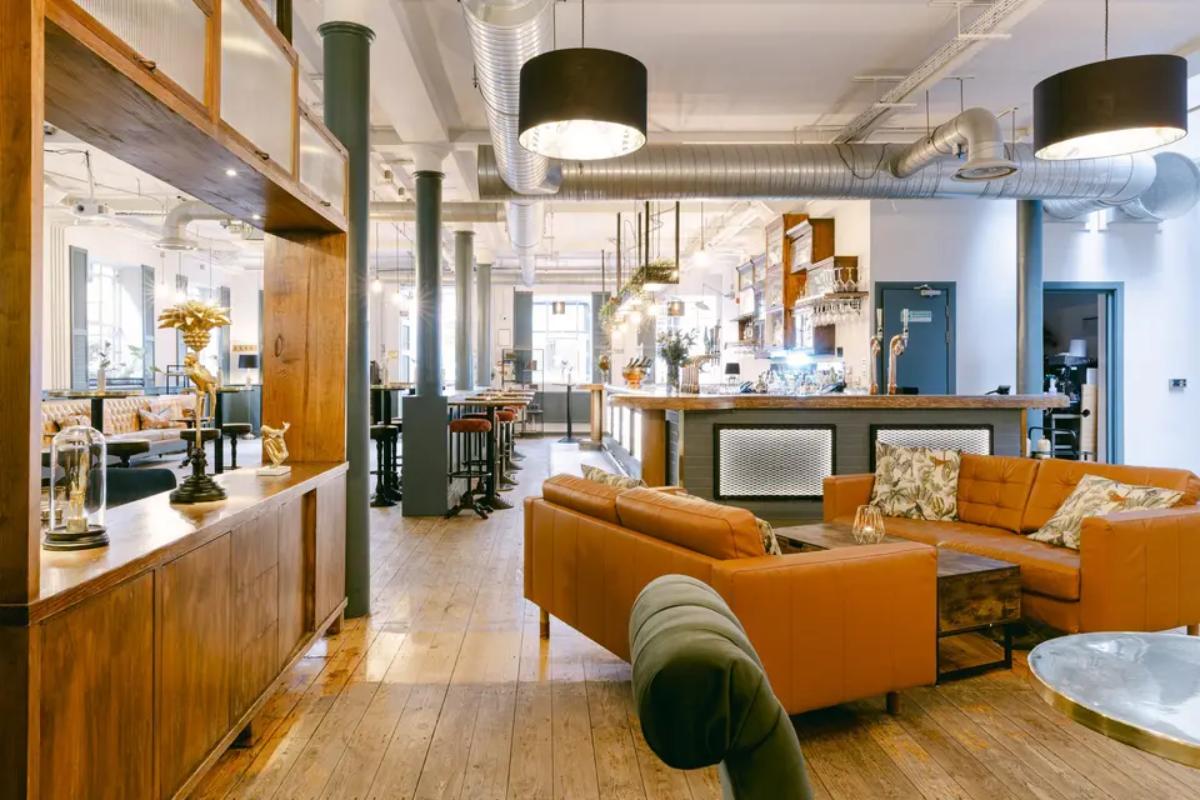  the inside of the tanner warehouse wedding venue with orange leather sofas and bar stools