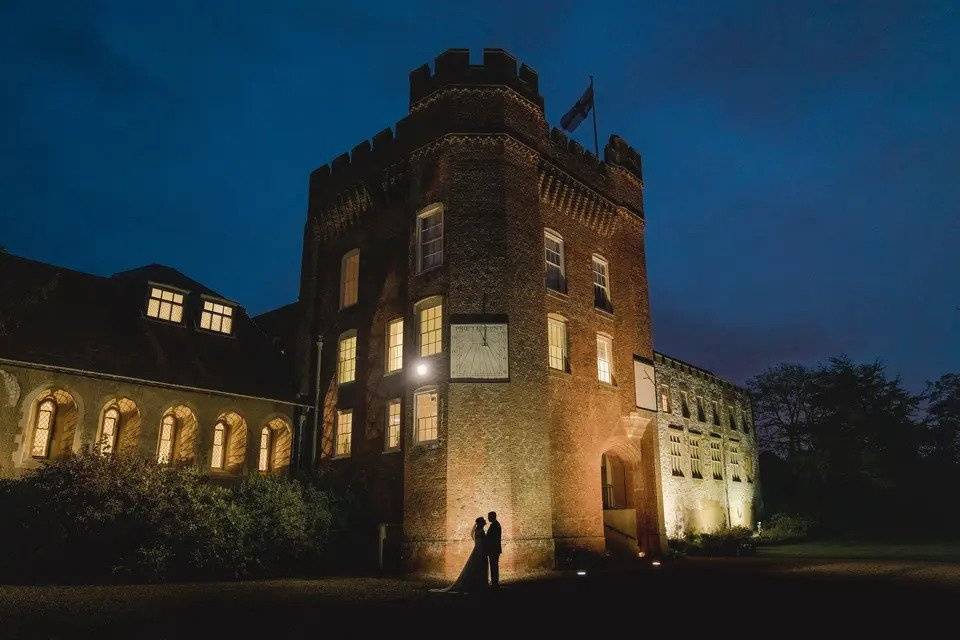 The exterior of Farnham Castle with the silhouette of a bride and groom