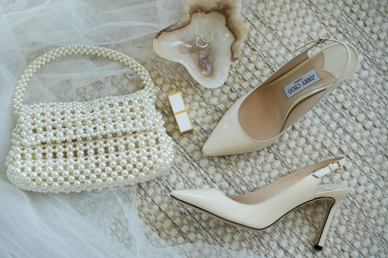 pearl handbag with white heels jewellery and lipstick