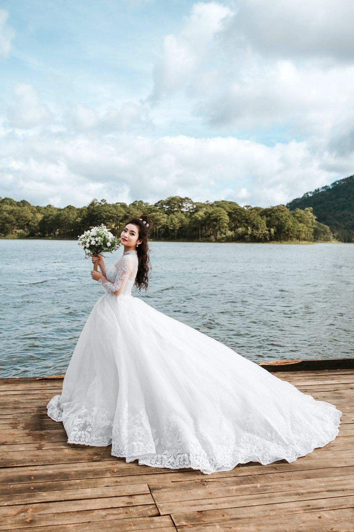 A bride standing by a lake
