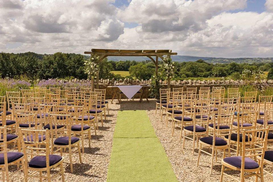 Outdoor ceremony set up with white Chiavari chairs