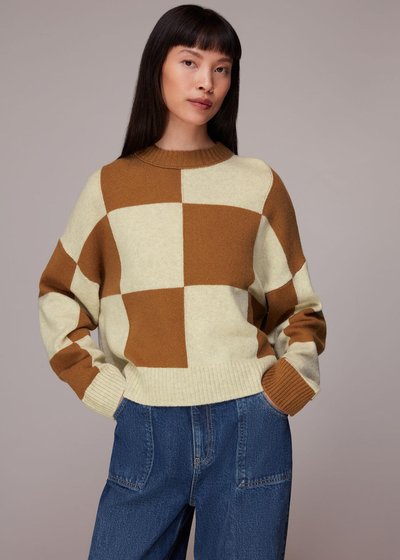 Model wearing a neutral check wool blend jumper with jeans