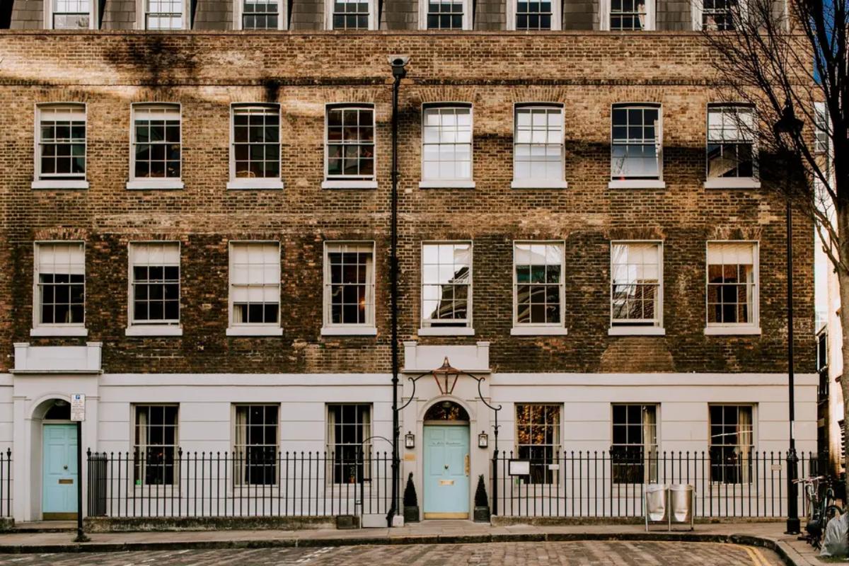  the front of the zetter clerkenwell townhouse with two baby blue doors, railings and exposed brick