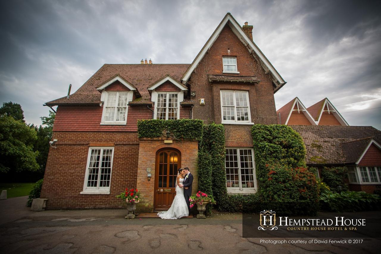 Bride and groom kissing outside of a hotel wedding venue