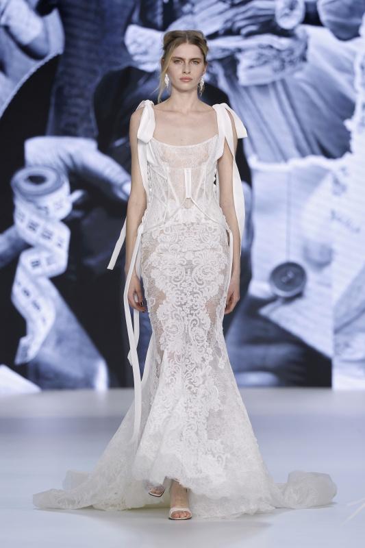 model at Barcelona Bridal Week 2026 styled by Yolancris wearing a lace, bow embellished mermaid fit wedding dress