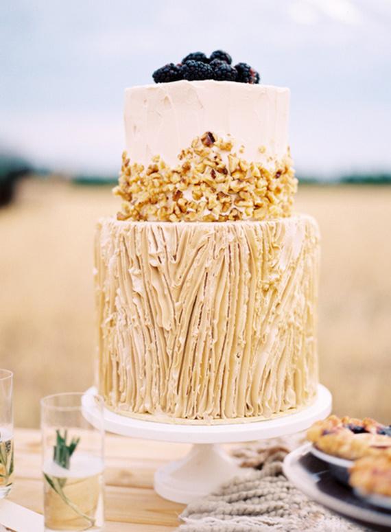 Two tiered sand coloured rustic wedding cake with texture and chopped nuts