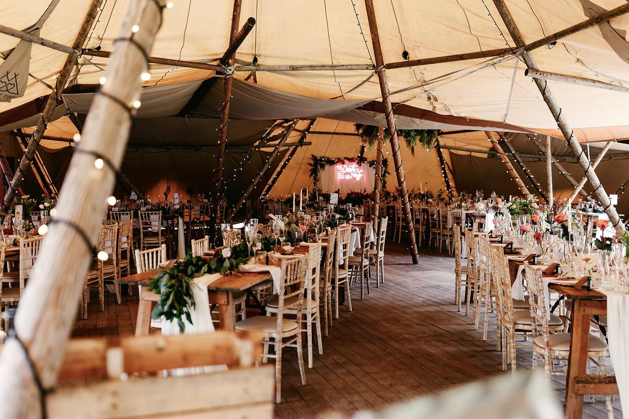 A tipi style marquee with beautiful flowers and fairylights
