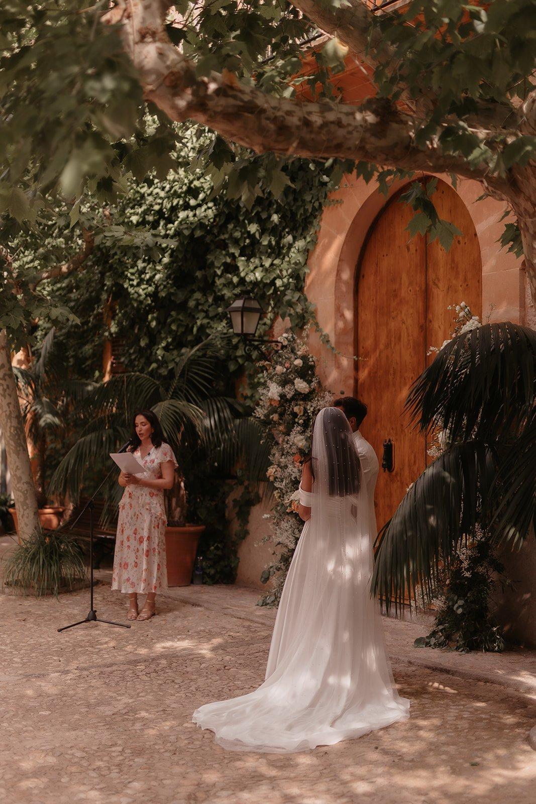 Josie and Cameron looking on as her twin sister conducts her wedding ceremony