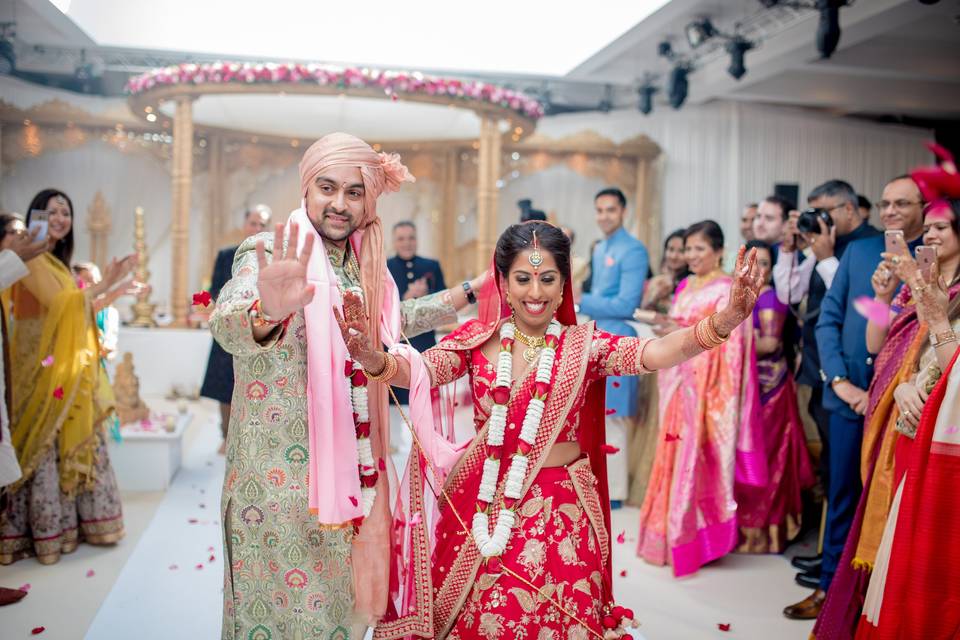 Indian couple dancing at their Asian wedding surrounded by a crowd of their friends and family in a hotel wedding venue