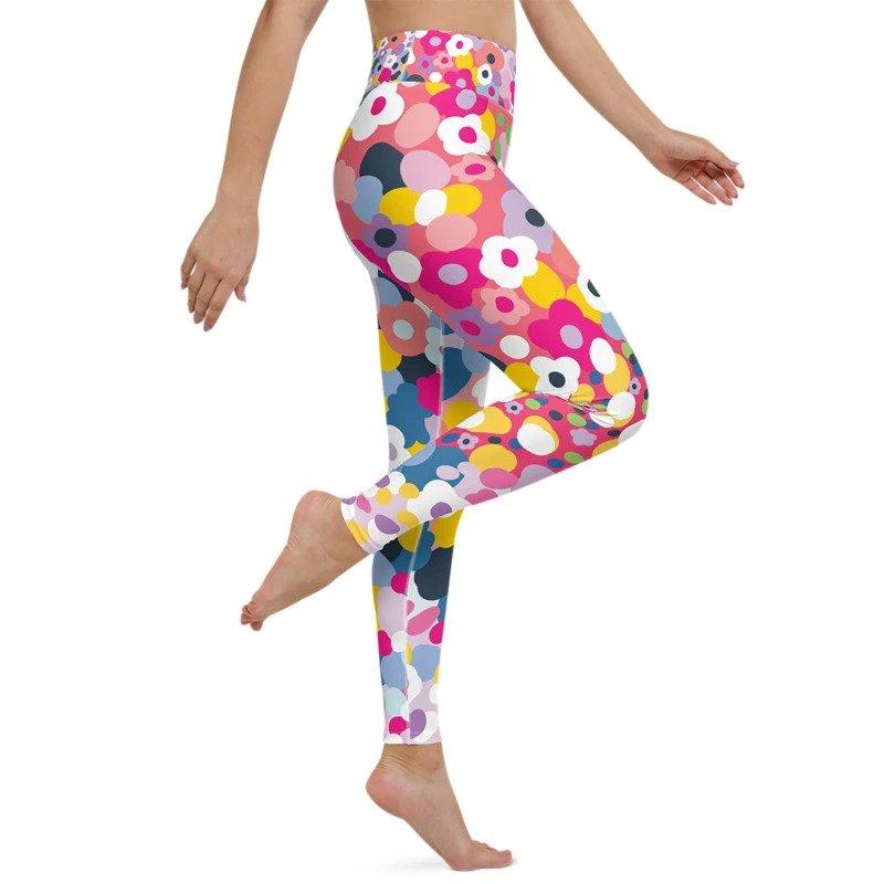 A cropped shot of a women's legs wearing pink high waisted yoga leggings decorated with retro style flowers in bright colours