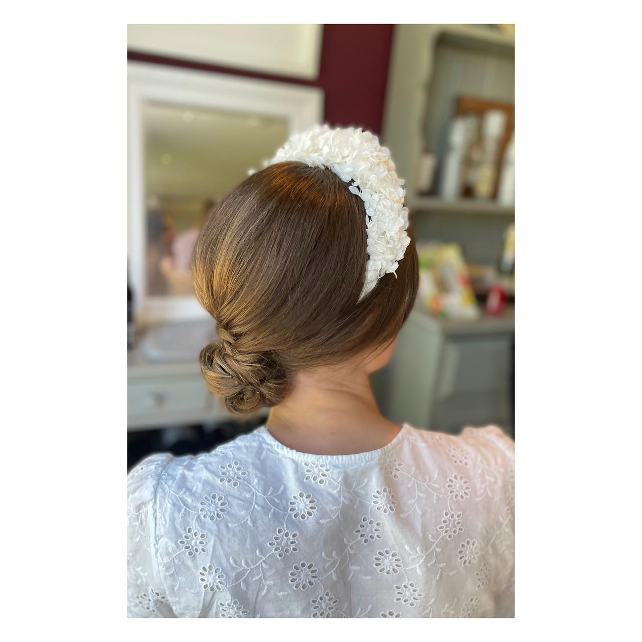 a bride with a low chignon bun and a white embellished headband