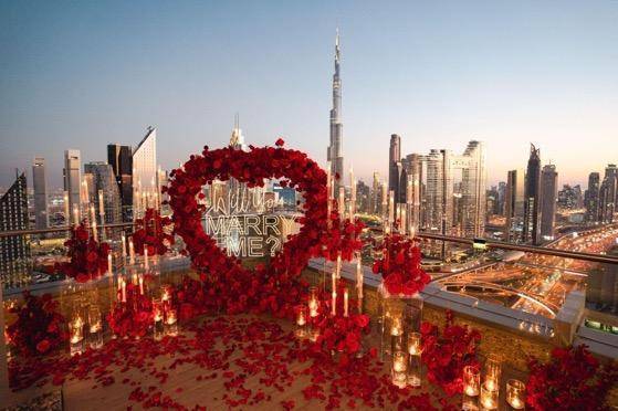 A 'will you marry me?' rose sign surrounded by candles on a rooftop in Dubai