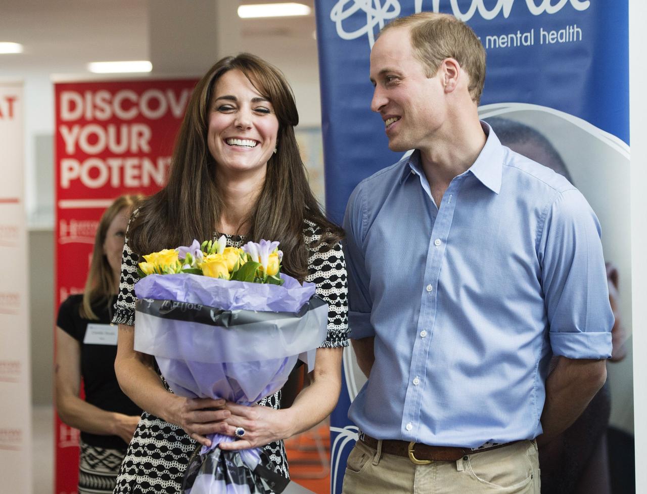 Kate Middleton holds flowers standing next to Prince William 
