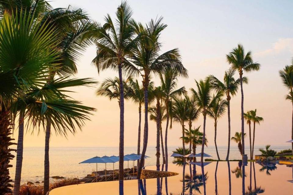 An endless pool with the reflection of the warm orange sunset at the One&Only Palmilla hotel in Mexico