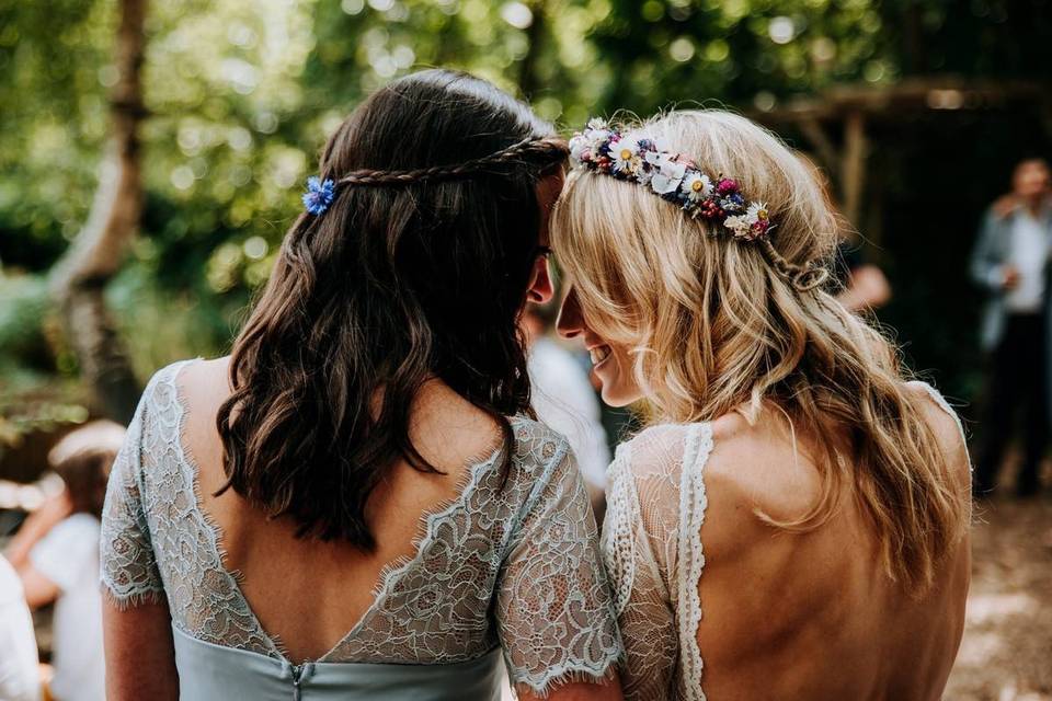 Bride and maid of honour lean on each other