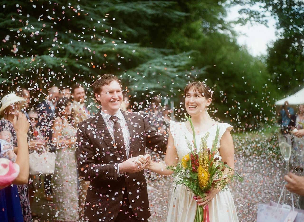 couple walking through confetti shot on film 
