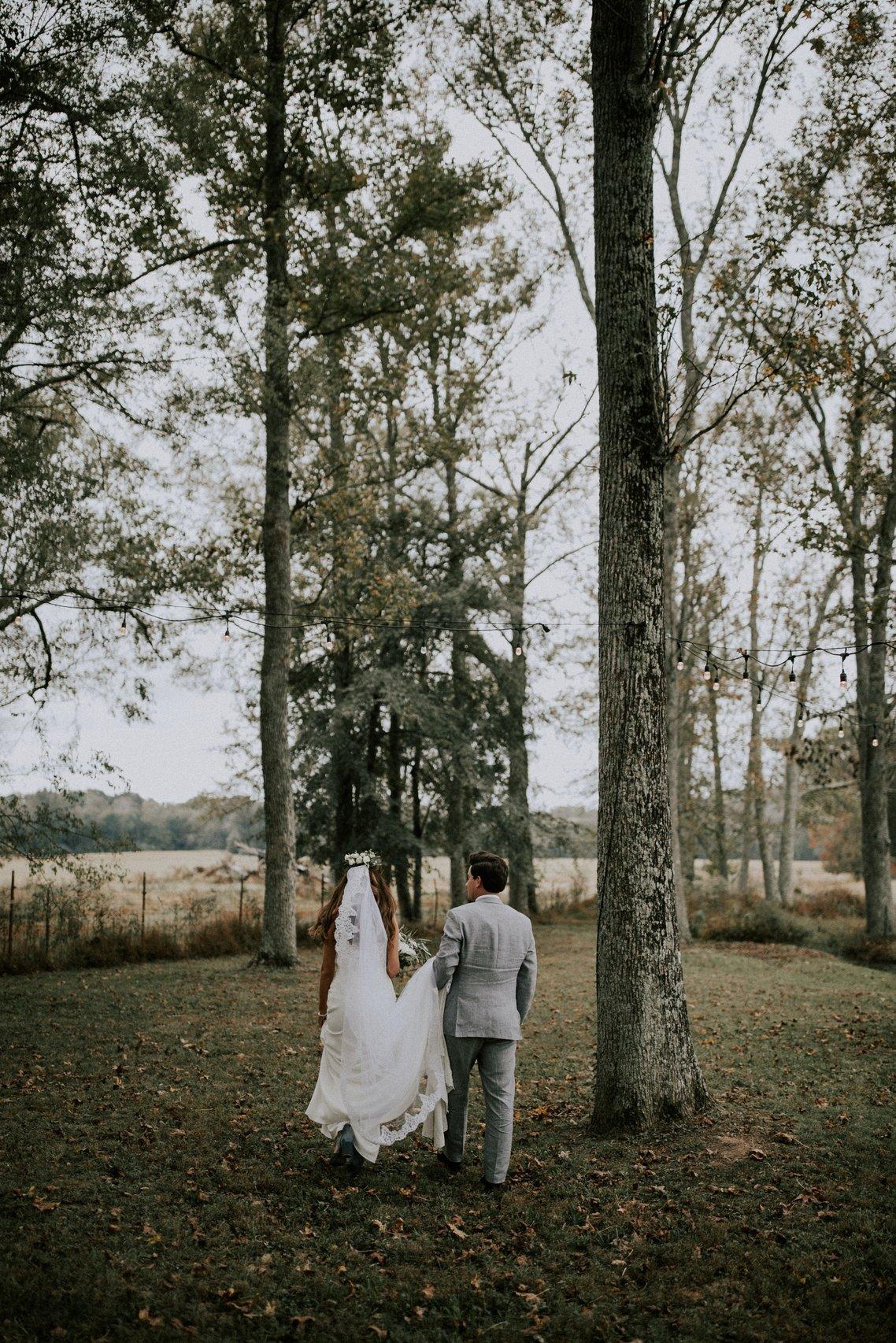 Bride and groom walking through the woods