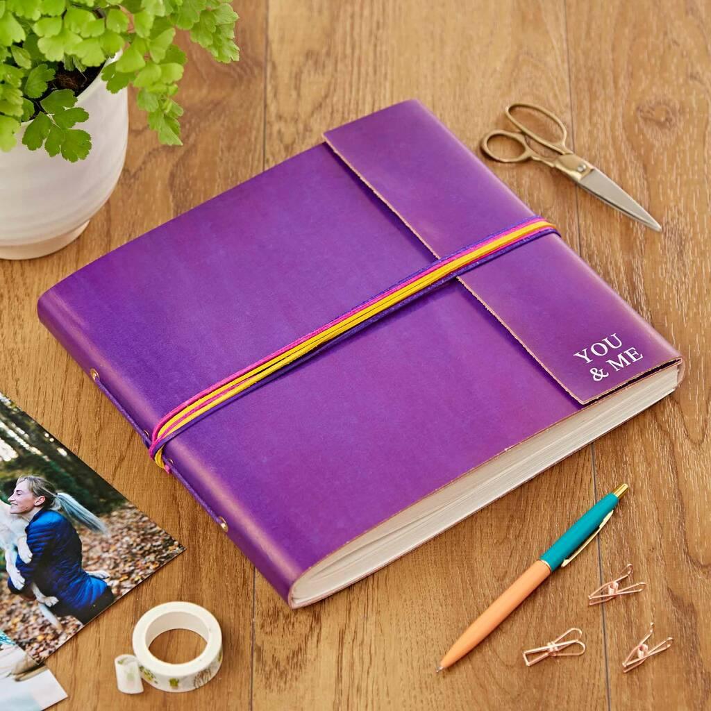 Image of a bright purple leather photo album on a table with the words 
