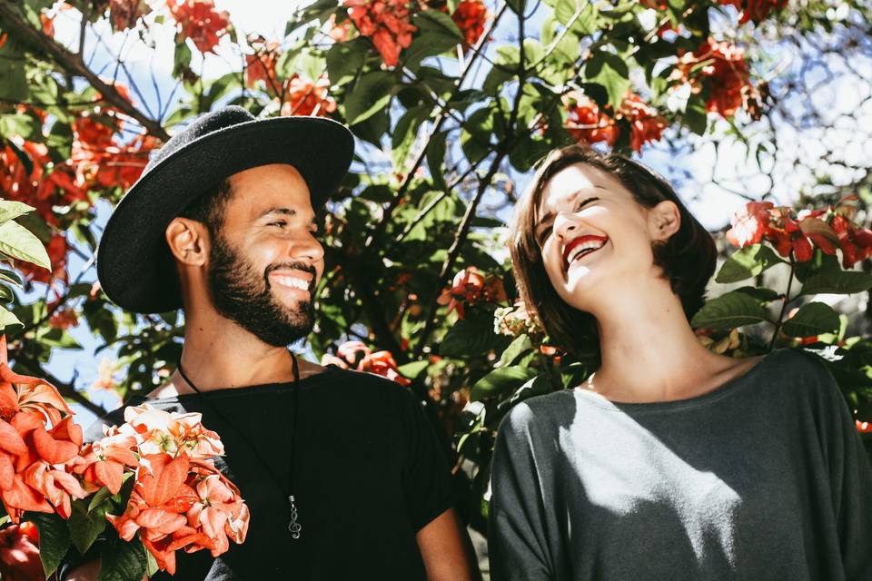 Couple laughing in front of some flowers