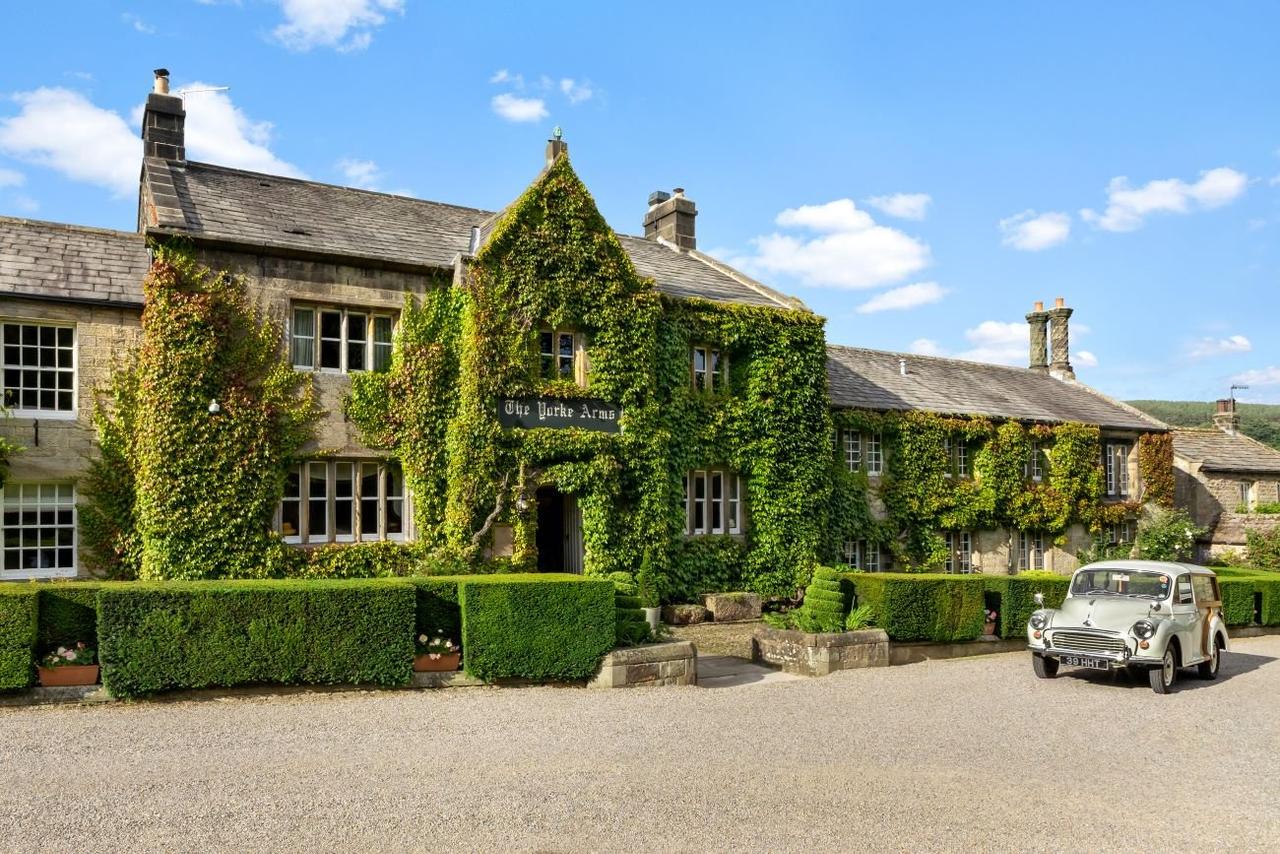 Exterior of an ivy-clad country house wedding venue with a wedding car in the foreground.