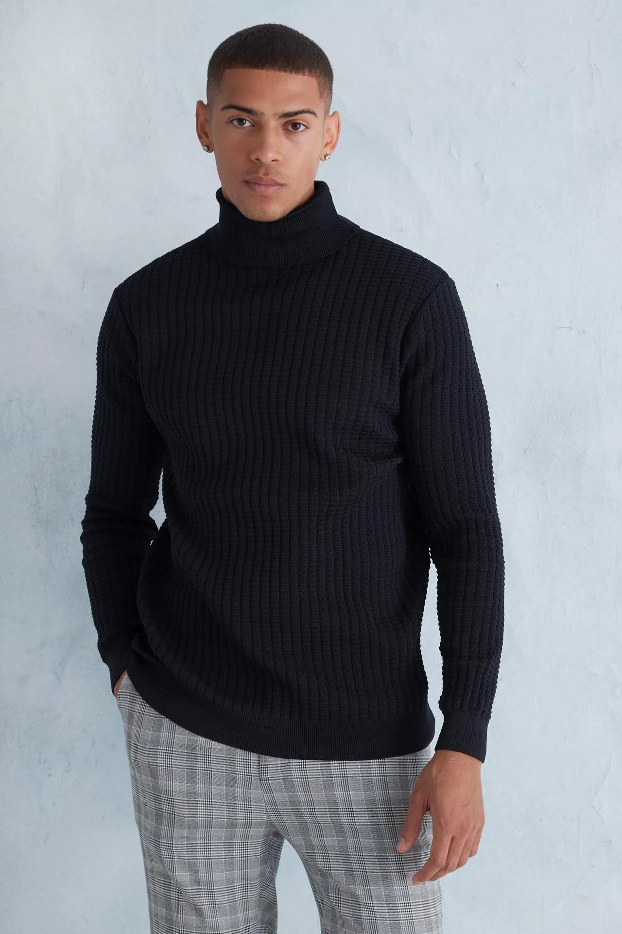 Model wearing a black ribbed roll neck jumper
