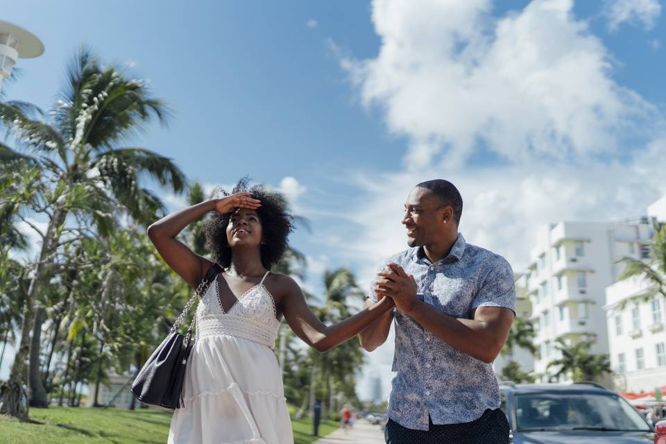 A couple holding hands in a tropical town.