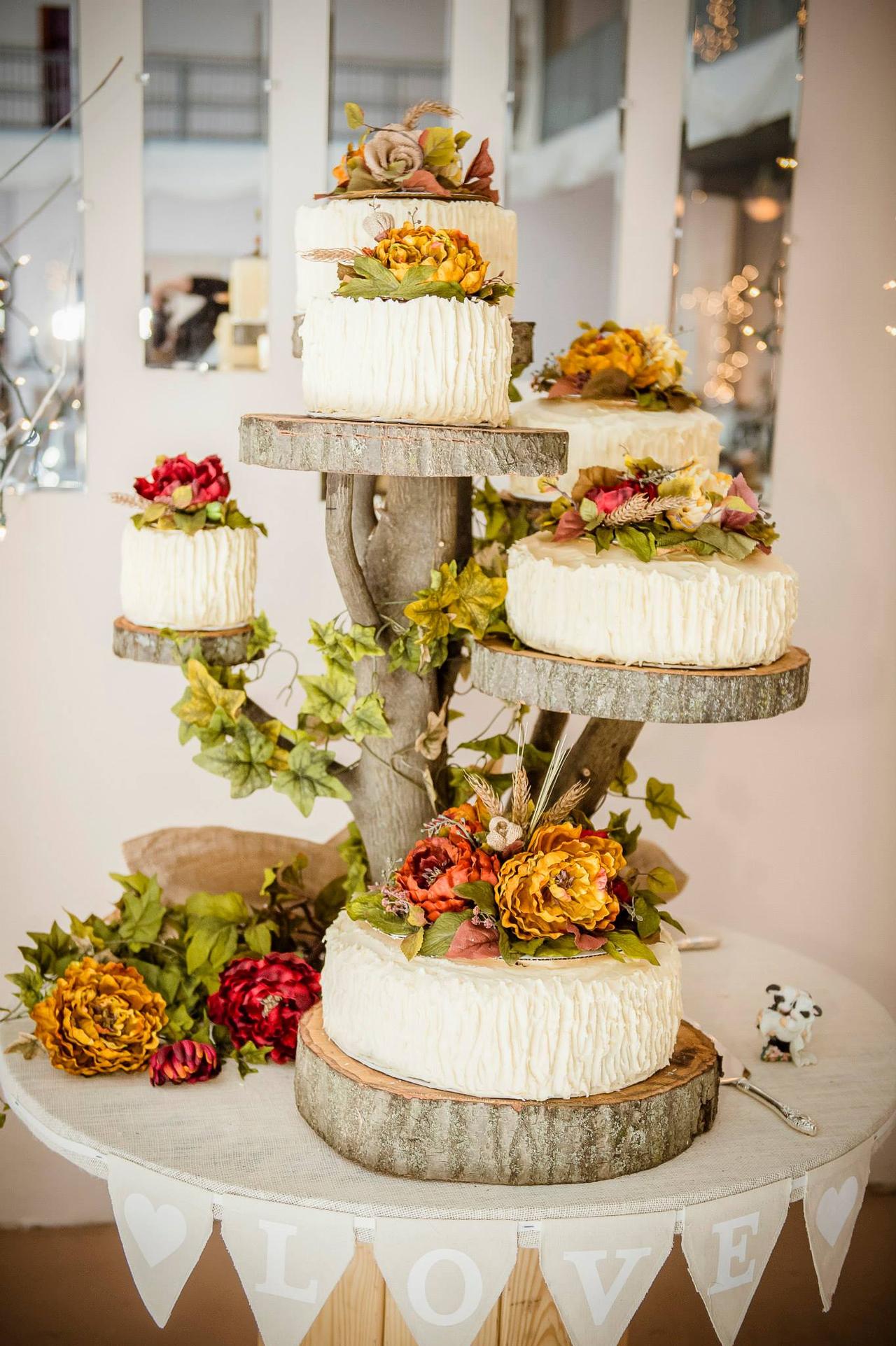 Six individual textured rustic wedding cakes with autumnal flowers