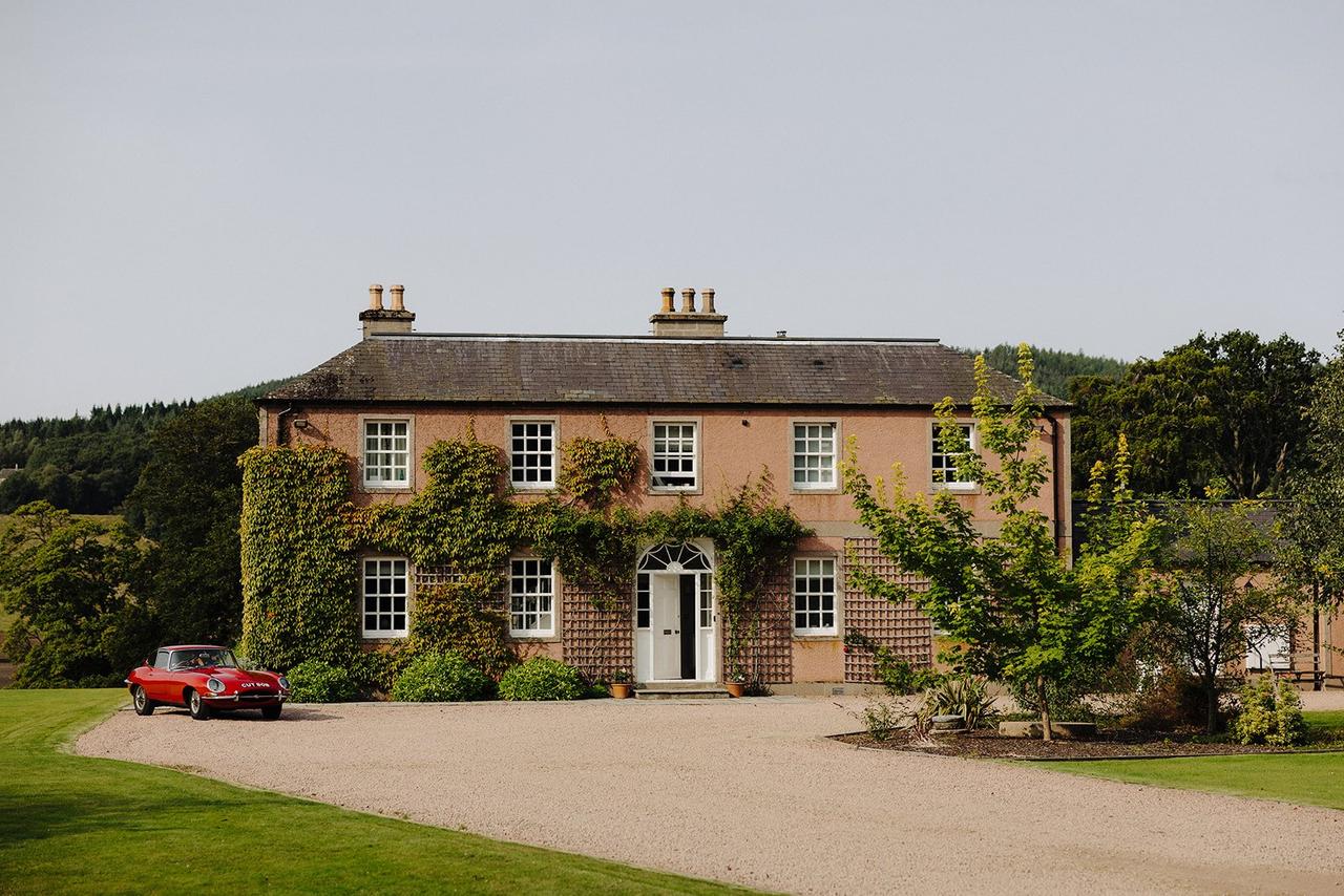 The exterior of a Georgian country house wedding venue in Scotland, surrounded by greenery.