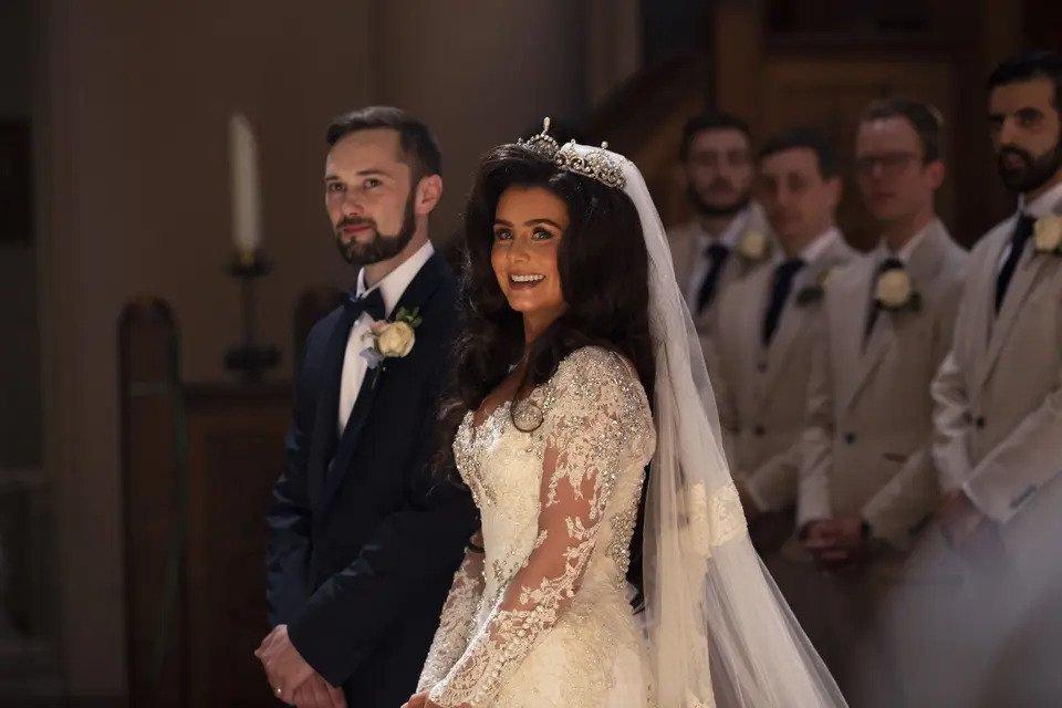 Bride and groom stand at the altar and bride smiles at the camera