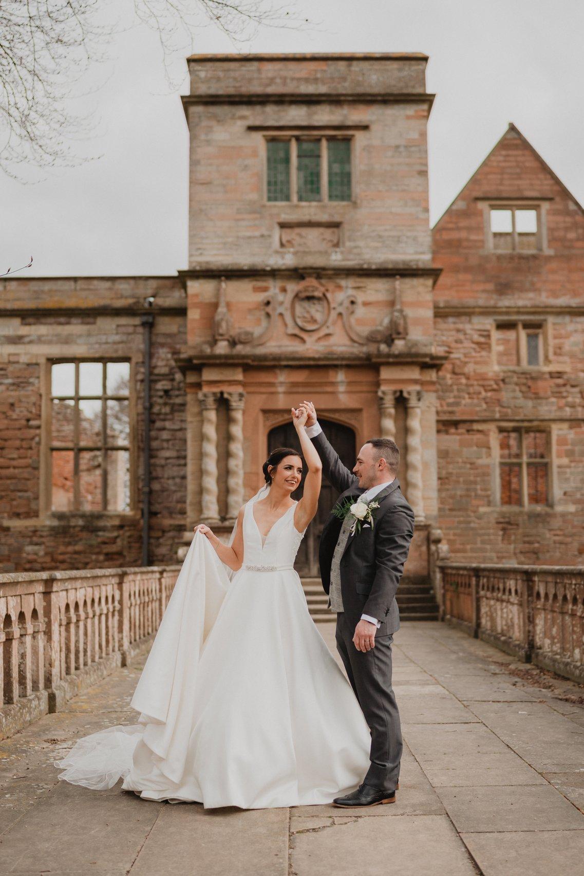 Bride and groom twirling outside of a stately home wedding venue