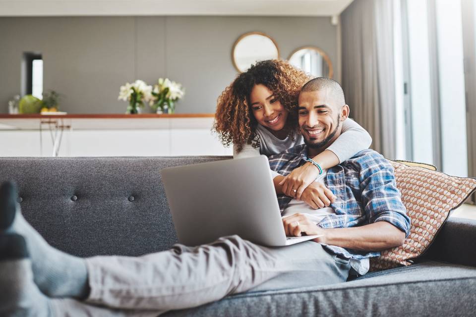 Couple making a wedding website on a laptop