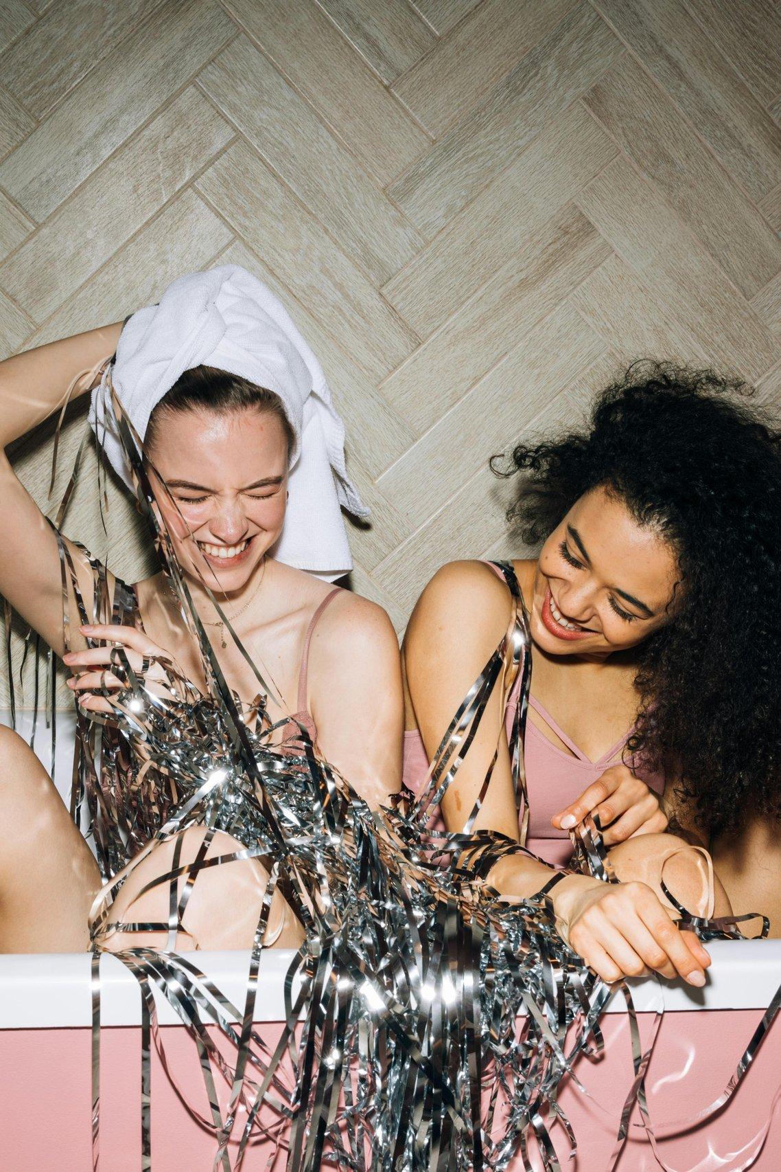 Two girls having a pamper night laughing