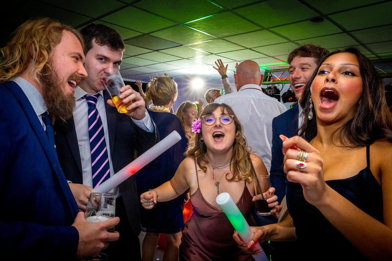 group of wedding guests singing karaoke on the dancefloor