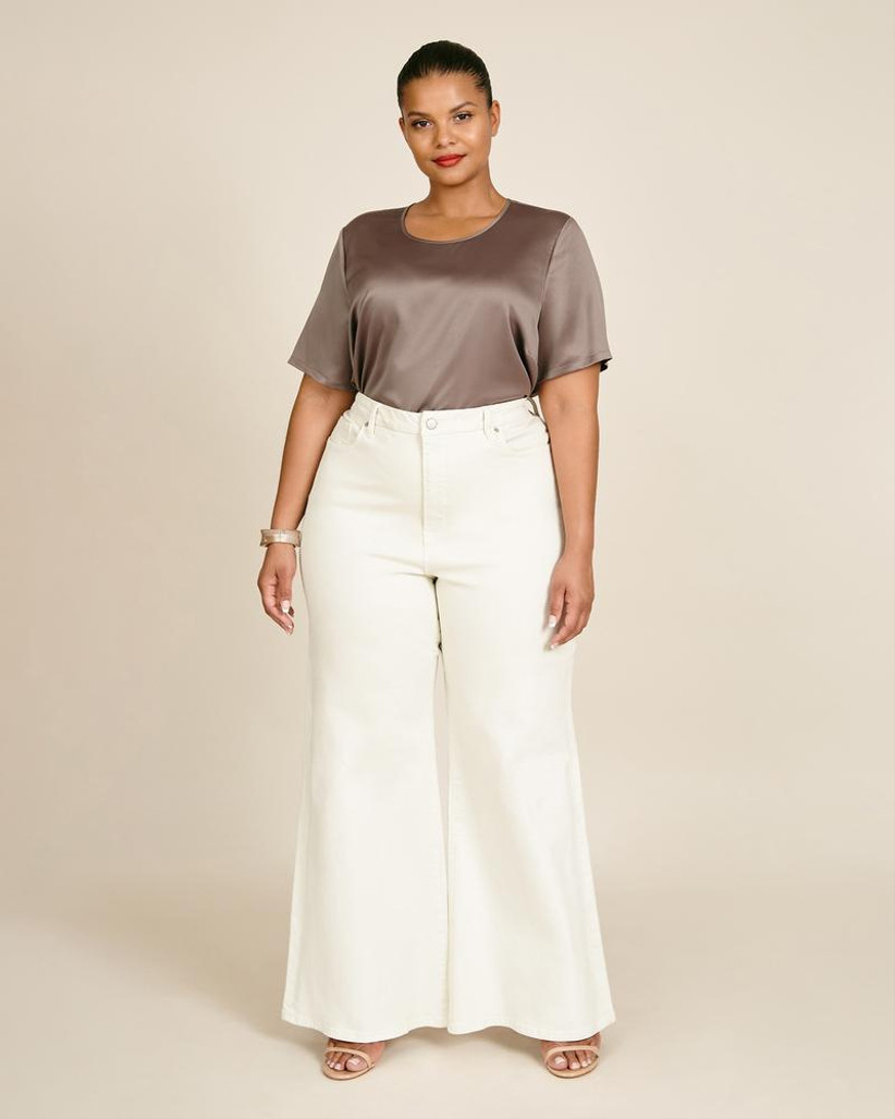 Model wearing a brown top and white trousers mother of the bride outfit