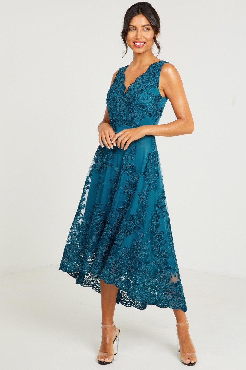 Model wearing an embroidered teal mother of the groom dress