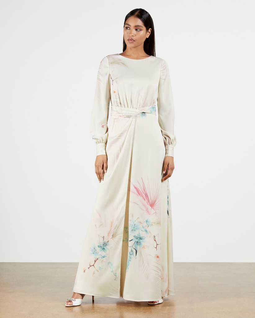 White maxi dress with long sleeves and pastel pattern on skirt