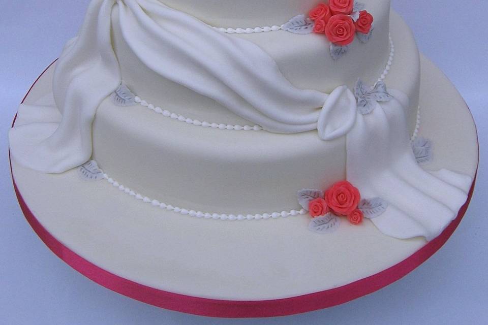 Three-tier white cake with drapes