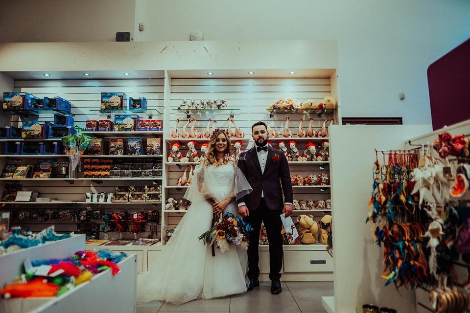 A couple standing in front of packed shelves in the Ulster Museum gift shop after their museum wedding ceremony