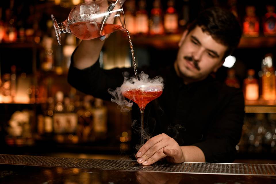 Mixologist pouring a cocktail