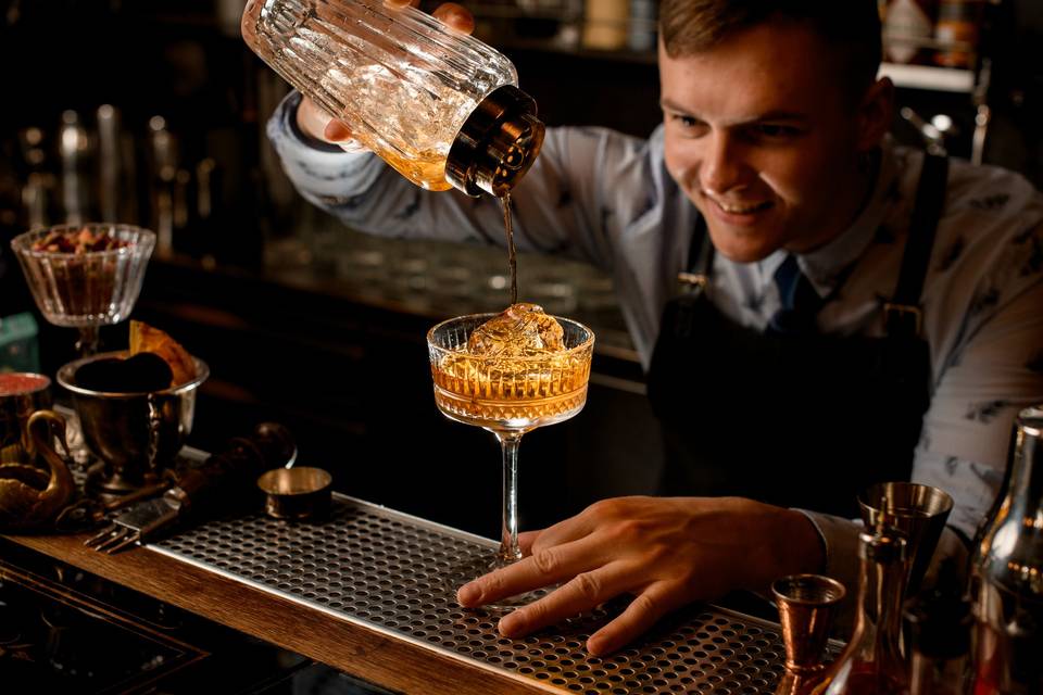 Mixologist pouring a cocktail