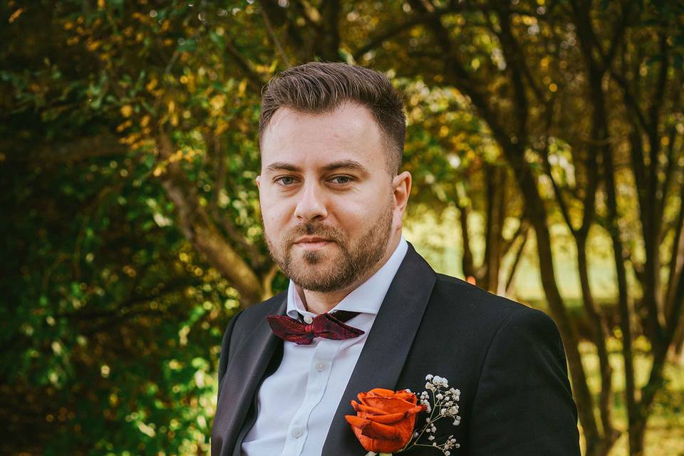 Groom sits on brick wall