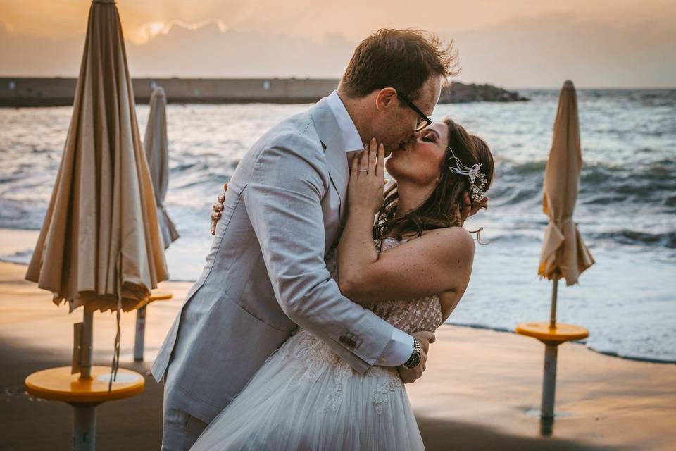 Bride and groom beach kiss