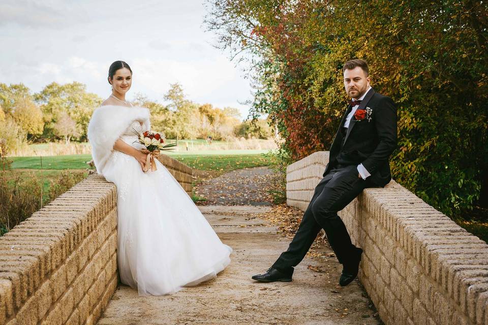 Bride and groom sit on bridge