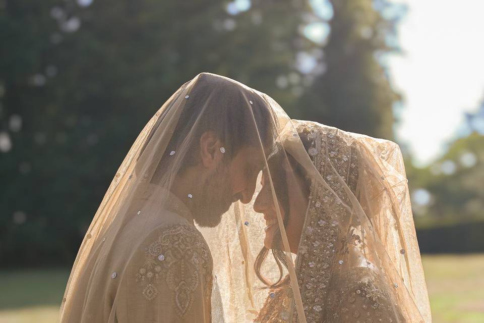 Bride and groom under veil