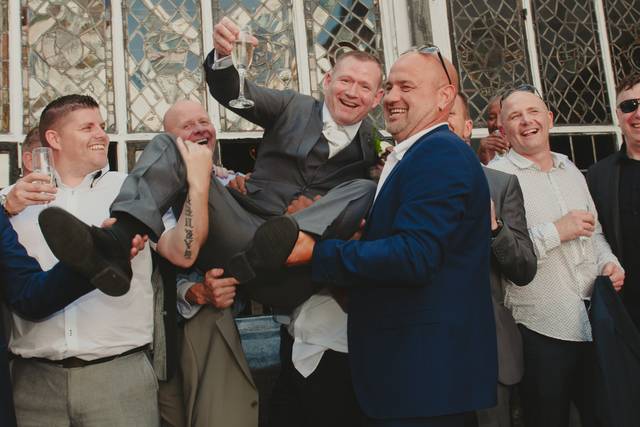 Groomsmen lift up groom