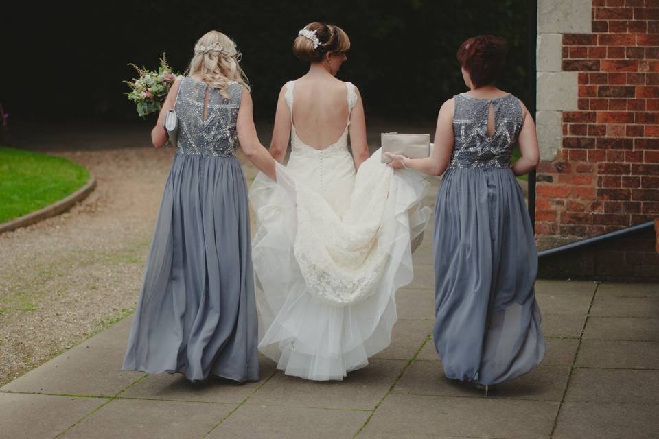 Bridemaids hold up dress