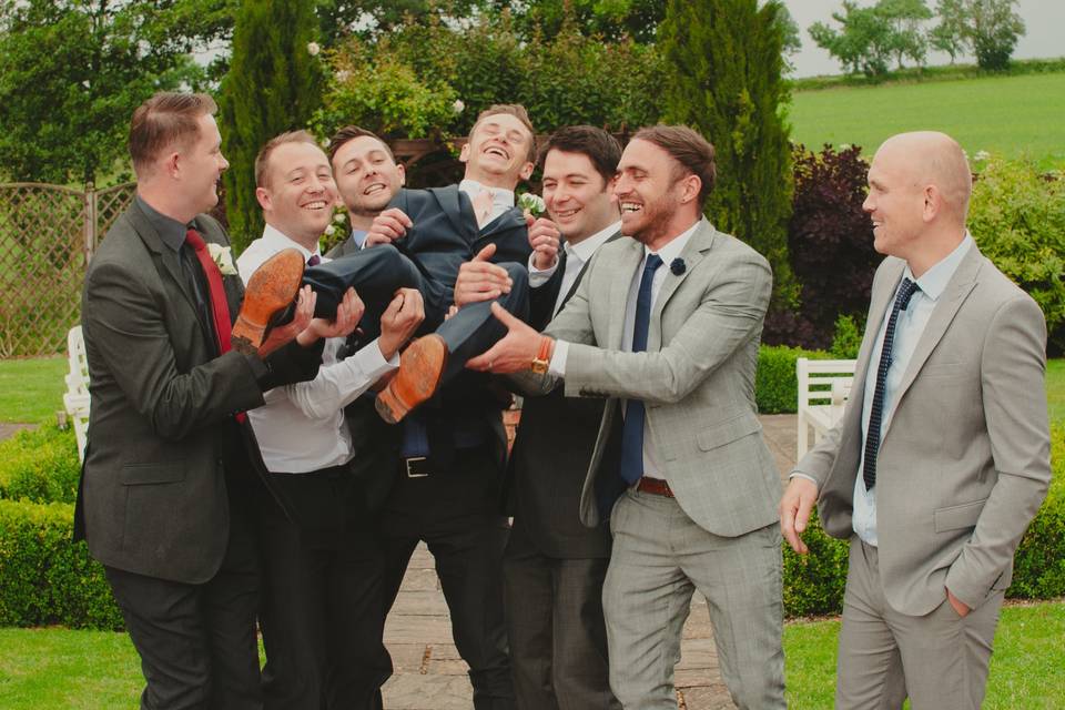 Groomsmen lift up groom