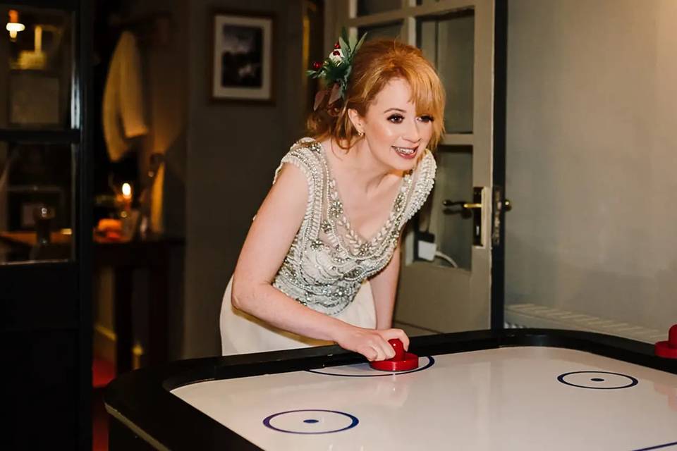 Bride playing air hockey