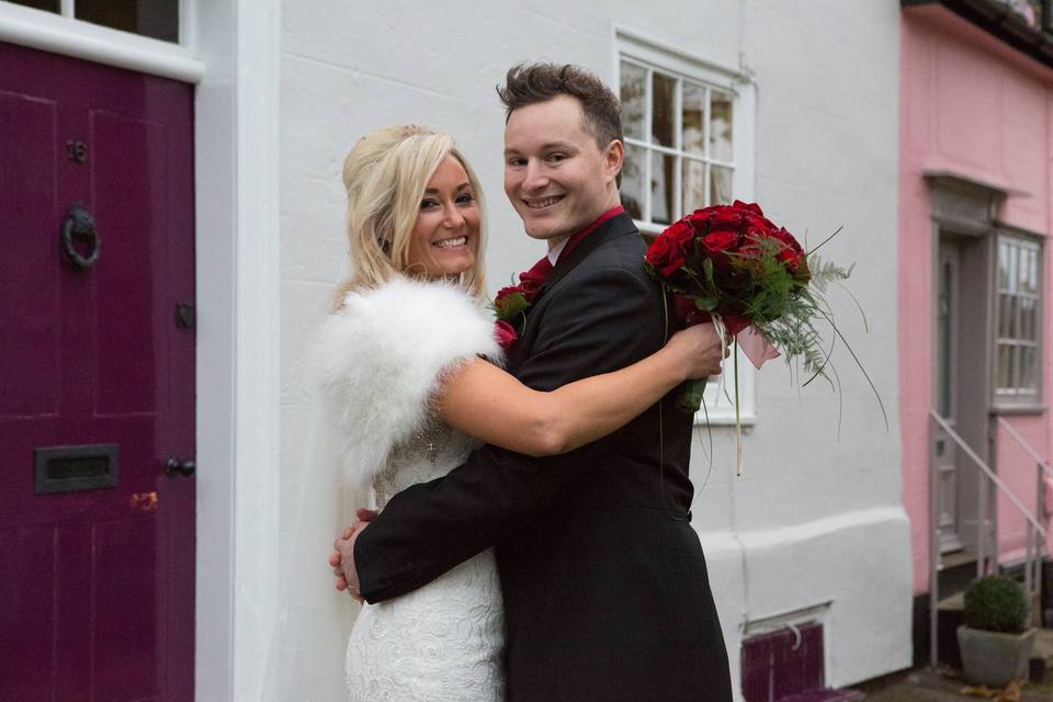 Bride and groom by a pink door